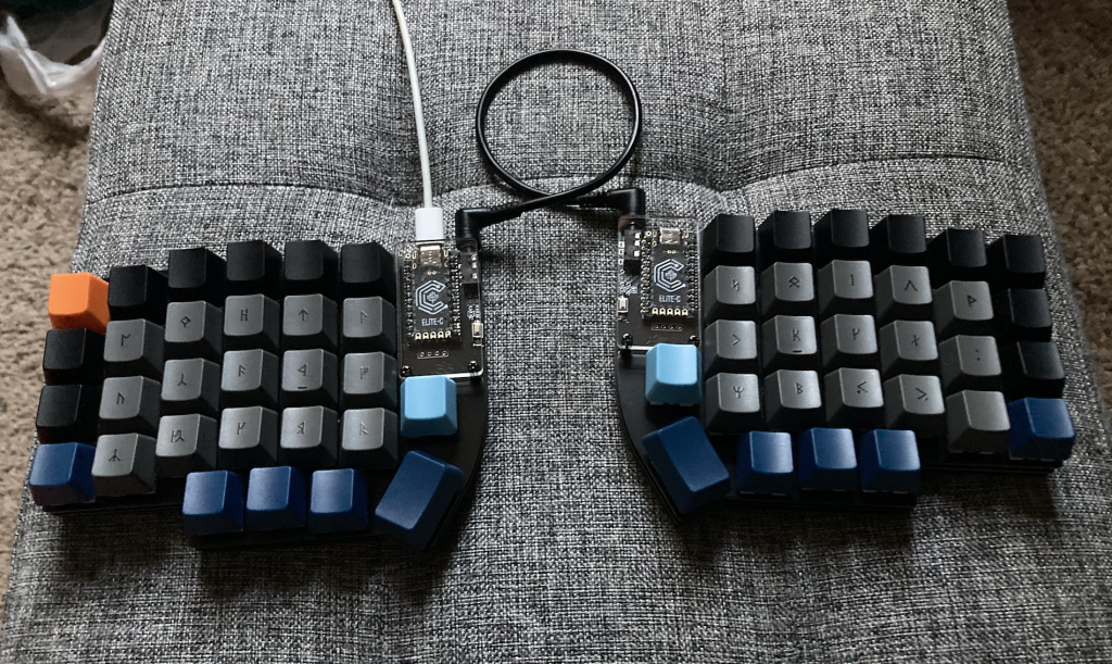 Photograph of my assembled Lily58 split keyboard, complete with dwarven rune keycaps